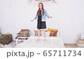 Happy teenage girl jumping on bed 65711734