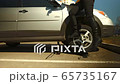 Ultra hard car wheel unscrewing by woman driver with wrench 65735167