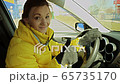 Woman driver is happy and smiles after wheel change 65735170