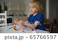 Little boy playing dough at home during coronavirus quarantine. Child molding from plasticine. 65766597