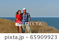 4K. Adult attractive couple stand against  sea  embracing each other     65909923