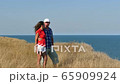 4K. Adult attractive couple stand against  sea  embracing each other     65909924