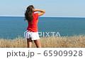 4K. Sexy  woman  in red blouse    against background of  sea close up 65909928