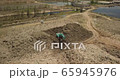 Aerial view of waste disposal open dump. Machine working in landfill. 65945976
