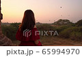Young woman traveler enjoying with balloons over ancient pagoda at Bagan, Myanmar at sunrise 65994970