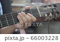 Young boy learn to play guitar, view close up to his hand. Guitarist edit guitar strings. 66003228
