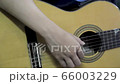 Young boy learn to play guitar, view close up to his hand. Guitarist edit guitar strings. 66003229
