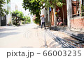 Blue collar worker bringing brick under sunlight in construction building zone in Vietnam. A young 66003235