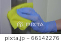 Hand in latex glove applies disinfectant alcohol antiviral spray on elevator push button control panel, wipes rag. Sanitizing, protecting infection, virus, covid 19, coronavirus, bacteria disinfection 66142276