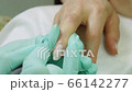Professional manicurist in latex gloves grinds fingernail woman client using milling cutter for hardware manicure, corrects cuticle in beauty salon or home. Closeup real time footage 66142277