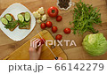 Top view female hands making sandwich with cucumber, arugula. Woman cuts with knife cherry tomato into slices on cutting board, put it on whole wheat rye bread. Fresh farm vegetables on wooden table 66142279