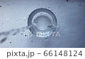Filling a clear glass with cold water on a white concrete background. Concept 66148124