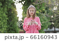 Profile of a serious girl using mobile phone in a park. 66160943