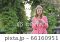 Girl typing text message on smartphone or hands using mobile phone in the park. 66160951