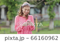 Woman checks on mobile phone at street. 66160962