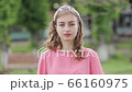 Portrait of happy cheerful young woman enjoying nature in the park. Beautiful girl smiling at camera outdoors. 66160975
