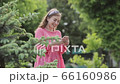 Beautiful Girl with charming Smile walking in the park and Using Mobile Phone. 66160986