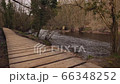 A wooden footpath at the side of a river in the woods. Nidderdale an Area of Outstanding Natural Beauty in North Yorkshire. A trail in the woods by the River Nidd 66348252