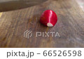 Slicing radishes with a knife on a wooden board 66526598