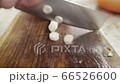 Slicing and chopping onion on a wooden board with special knife. 66526600