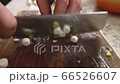 Slicing and chopping onion on a wooden board with special knife. 66526607