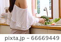 Closeup young woman washing broccoli and vegetables to prepare for breakfast in the kitchen. 66669449