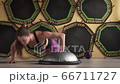 Strong fitness woman doing jumping push ups at gym 66711727