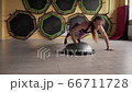 Fitness woman doing jumping push ups exercise at gym 66711728