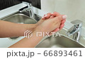 Close-up of woman using hand sanitizer gel on the background of the sink 66893461
