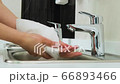 Caucasian woman cleaning her hands with white soft tissue paper in the clinic 66893466
