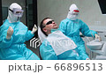 The dentist's assistant lowers the patient on a chair before checking the teeth 66896513