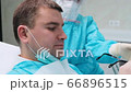 Close-up of the male client wears black glasses and falls into a dental chair 66896515