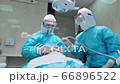 Woman dentist in a protective suit and female assistant works with a patient 66896522