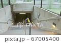 young man who climbs the stairs at the station and holds a phone in his hands 67005400