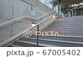 young man who climbs the stairs at the station and holds a phone in his hands 67005402