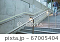 young man who climbs the stairs at the station and holds a phone in his hands 67005404