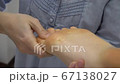 Close up of woman therapist massaging the feet of her patient in spa salon Close up of woman therapist massaging the feet of her patient in spa salon 67138027