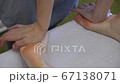 Close up of woman therapist massaging the feet of her patient in spa salon Close up of woman therapist massaging the feet of her patient in spa salon 67138071