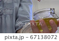Female hands take out massage oil from a glass jar Female hands take out massage oil from a glass jar 67138072