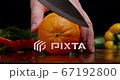 Man slicing orang on a cutting board to make some vitamins salad. Vegetarian food for special diet. 67192800