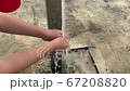 Child washing hands outdoors 67208820