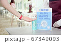 Asian restaurant waitress use hand sanitizer, alcohol gel on customer's hand. New normal 2020 67349093