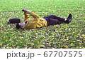 Alone men with yellow jacket using smartphone in the park of the fall. 67707575