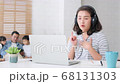 Asian mother work at home with family, father, daughter, and son sit together on sofa couch 68131303