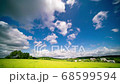 White clouds on blue sky over green field of days time lapse 68599594