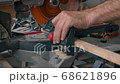 A carpenter works on a circular electric saw. A close-up of the hands of a worker and machine parts. Slow motion footage. 68621896
