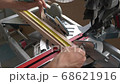 A carpenter works on a circular electric saw. A close-up of the hands of a worker and machine parts. Slow motion footage. 68621916