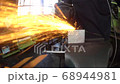 金属製の製品をグラインダーにてバリ取りする作業 68944981