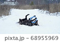 labrador funny lying on a snowy country road, playing with a toy 68955969
