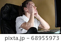 girl looks tiredly at the monitor, sitting at work at night, the camera moves 68955973